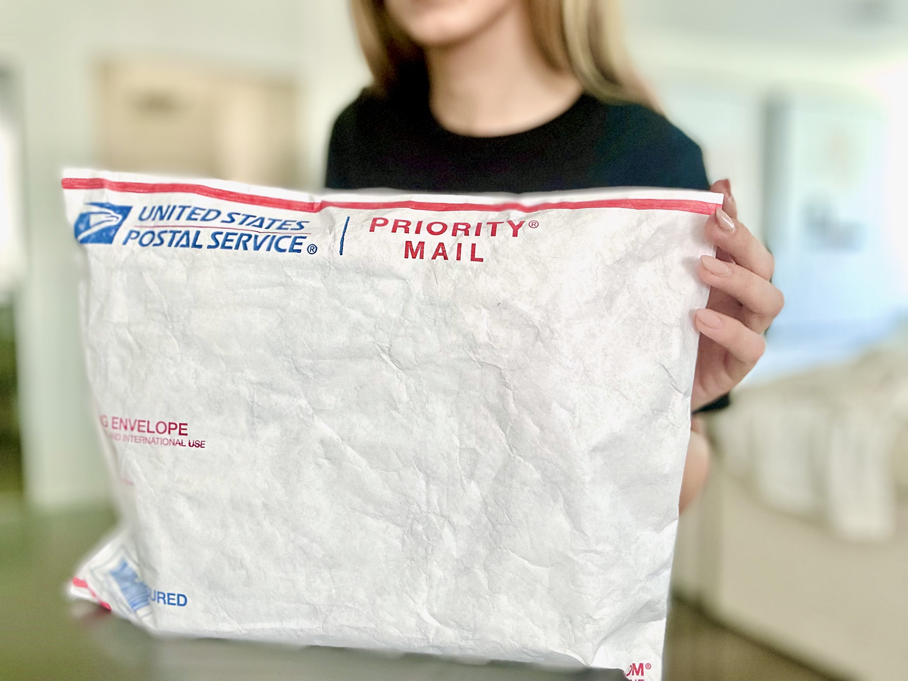 Person holding USPS packaging